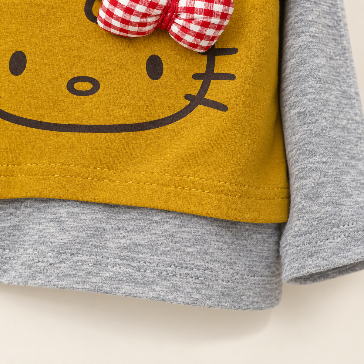 Yellow cat bow top hem detail.
