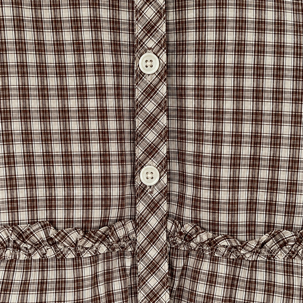 Plaid blouse white buttons, diagonal placket and ruffled hem detail.